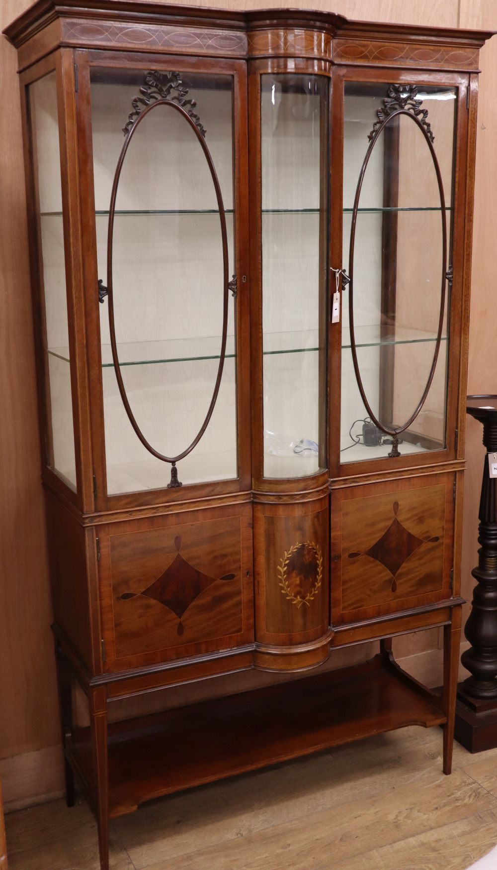 A Sheraton revival inlaid mahogany bow front display cabinet, W.110cm, D.50cm, H.198cm